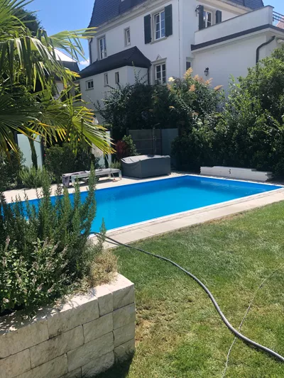 Bild zeigt Außenanlage mit Pool und gestaltetem Garten